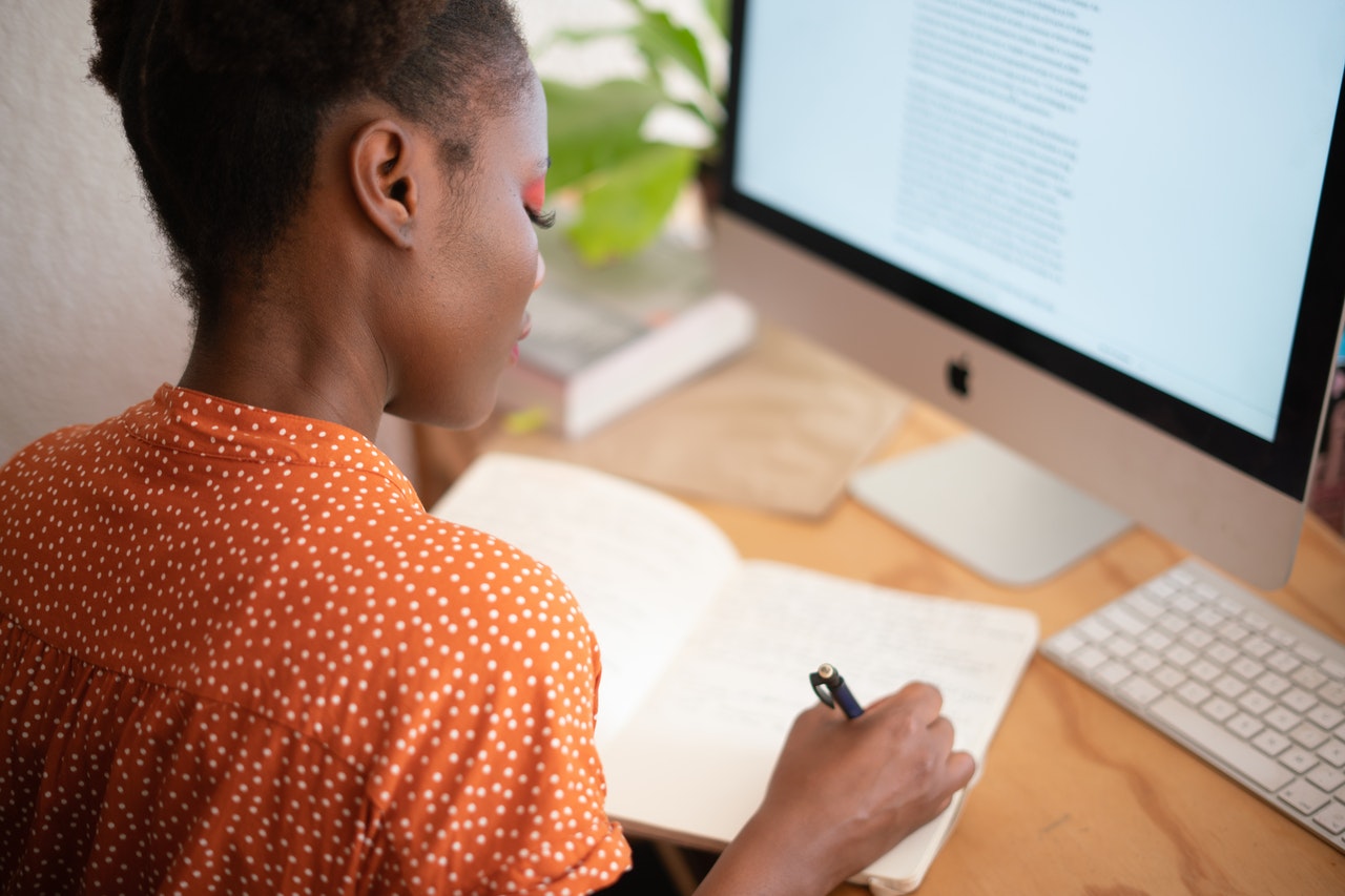 woman-writing-on-her-notebook